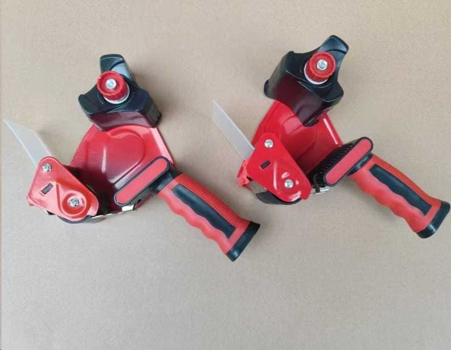 Tape gun dispensers ready for carton sealing